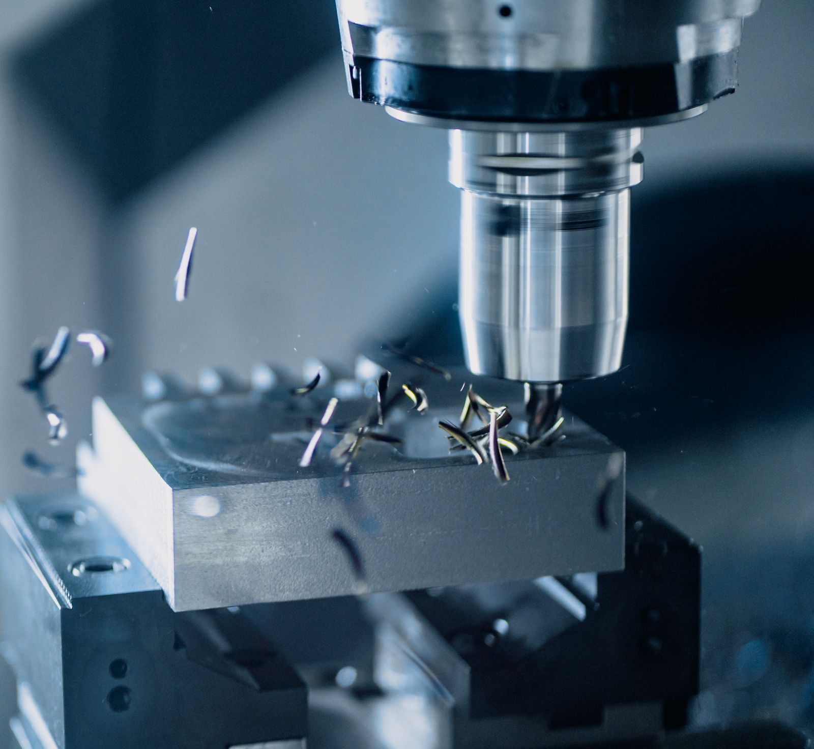 CNC milling machine cutting a metal workpiece with coolant.
