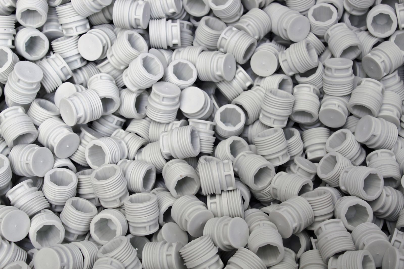 Injection-moulded plastic components with runners on a production table.