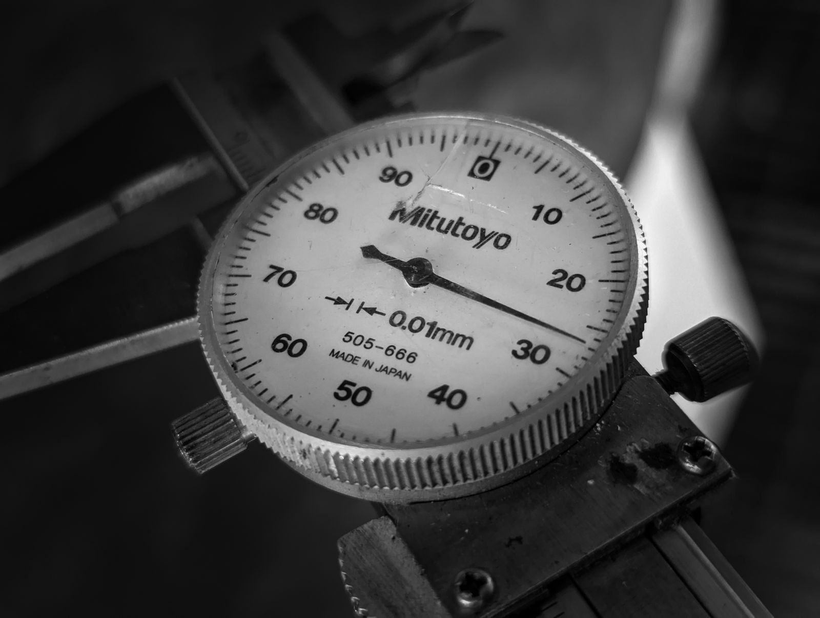 Coordinate measuring machine inspecting a precision machined part in a metrology room.